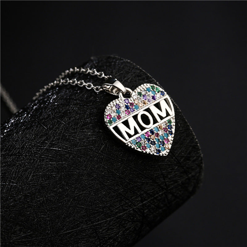 Silver heart MOM pendant necklace on a black canvas