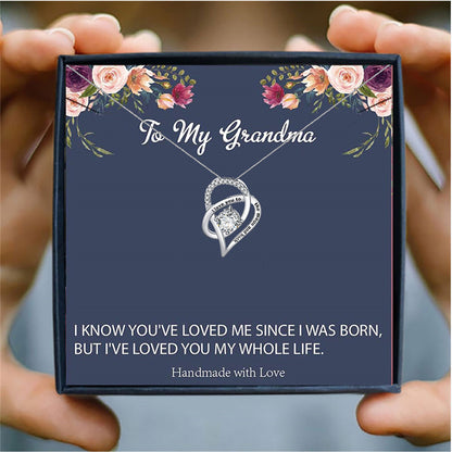 someone holding a  card box with a silver heart necklace for grandma