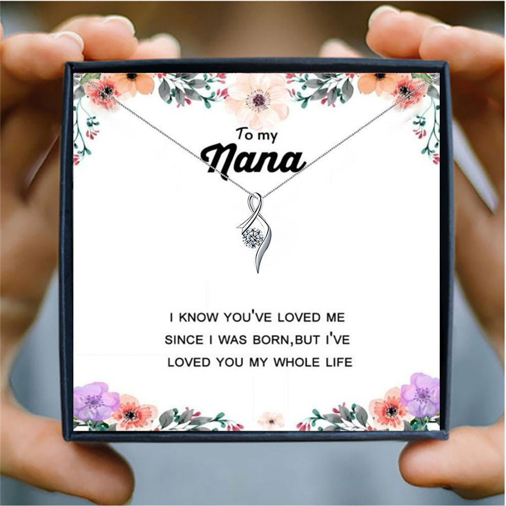 someone holding a  card box with a silver heart necklace for nana