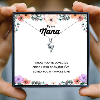 someone holding a  card box with a silver heart necklace for nana