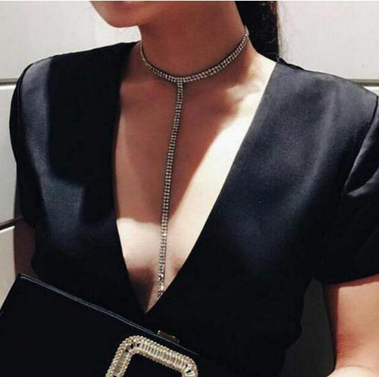 woman in a black dress wearing a silver crystal stone necklace