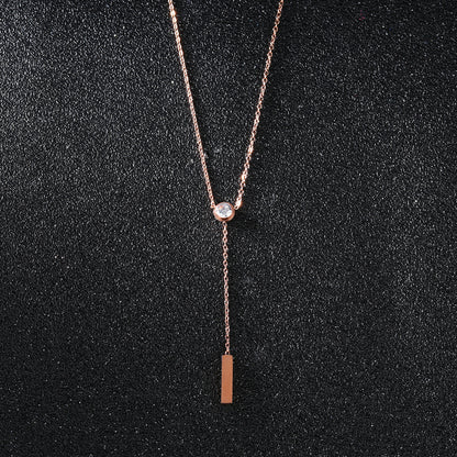 elegant rose gold necklace with a diamond on a black canvas