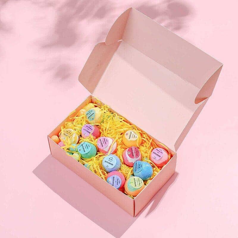 A set of Organic Essence Oil Bubble Bath Balls packaged in a box on a pink background