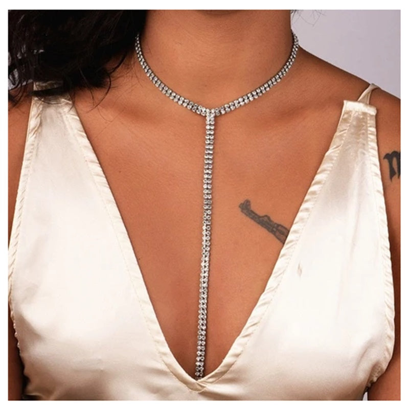woman in a white dress wearing a silver crystal stone long necklace