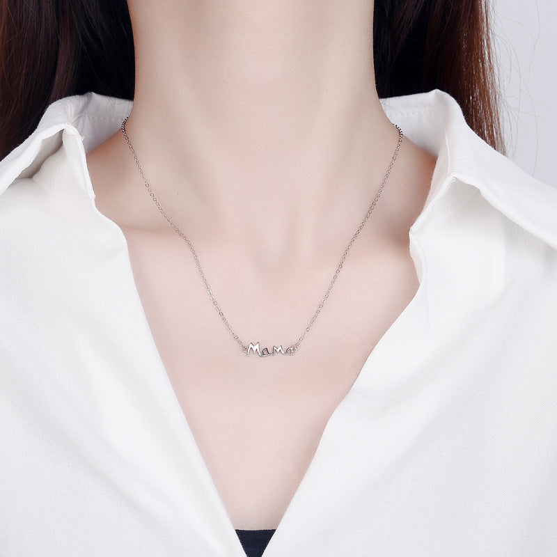 A woman wearing a silver letter mom necklace 