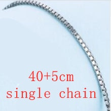 A silver single chain measures on a blue canvas