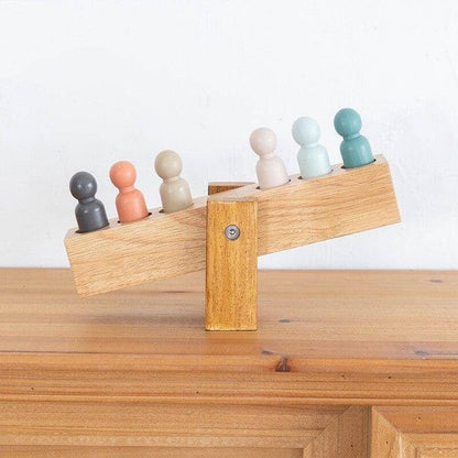 Miniature wooden figures on a seesaw for children's room decor