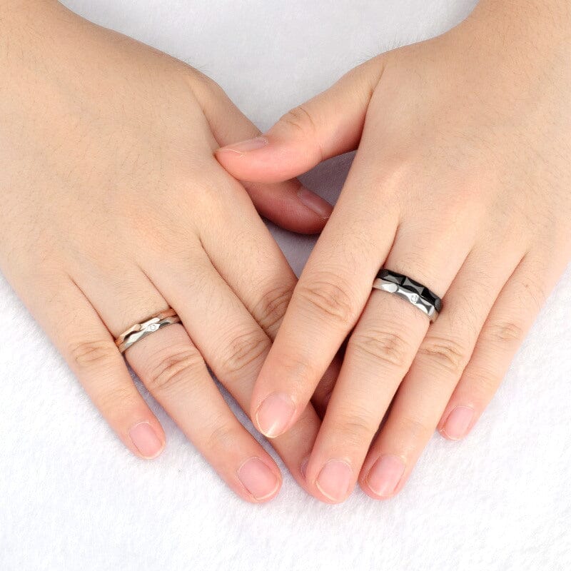 Close-up of hands wearing eco-friendly titanium steel couple rings, showcasing their unique design