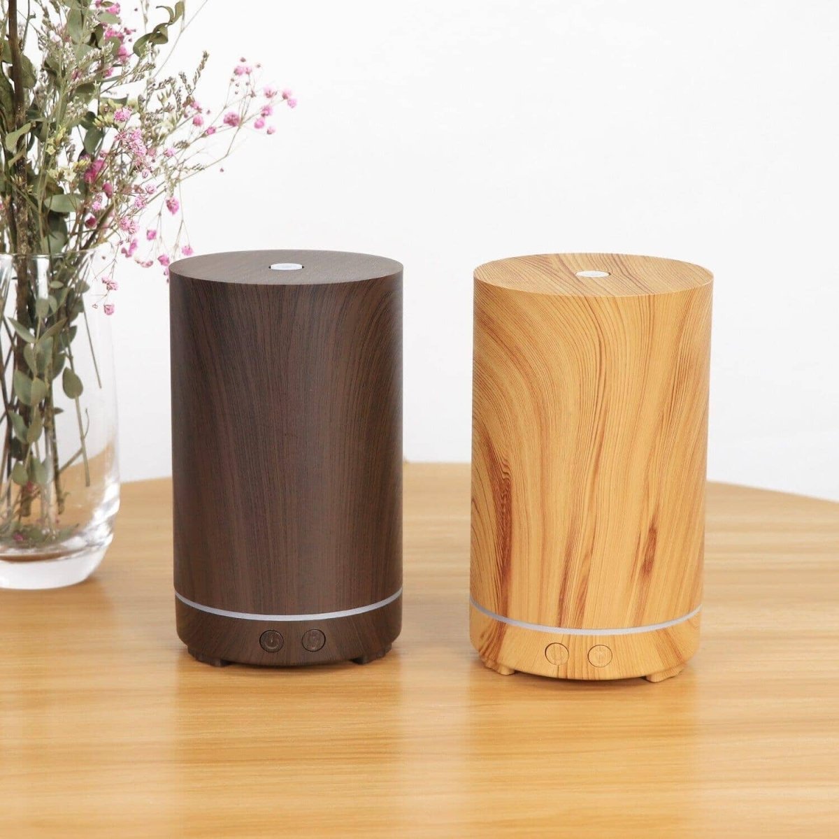 two eco-friendly-wood humidifiers on a wooden table