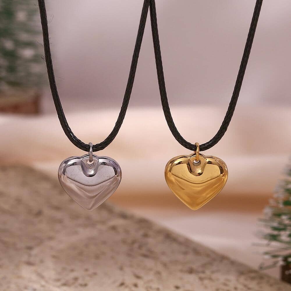 A silver heart pendant and a gold pendant with a rope chain