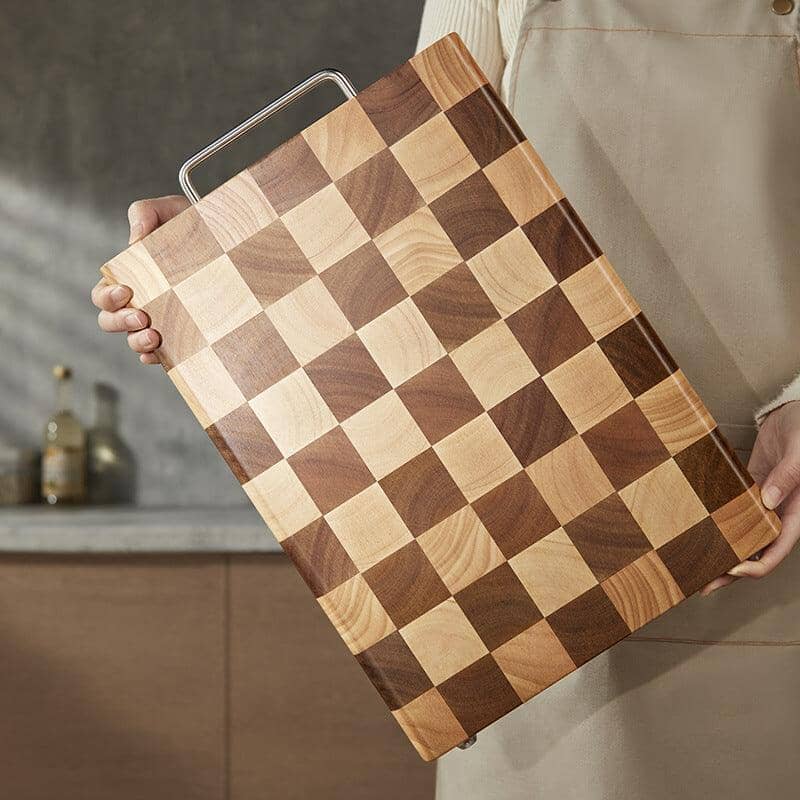 Someone holding a wood chopping board with square designs