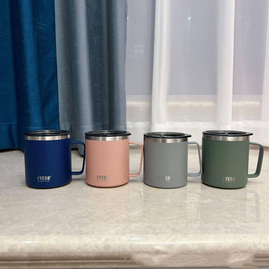 Four different eco-friendly stainless steel mugs in different colors on a marble countertop