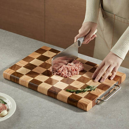 A woman chopping meat on an acacia wood checkerboard over a granite countertop