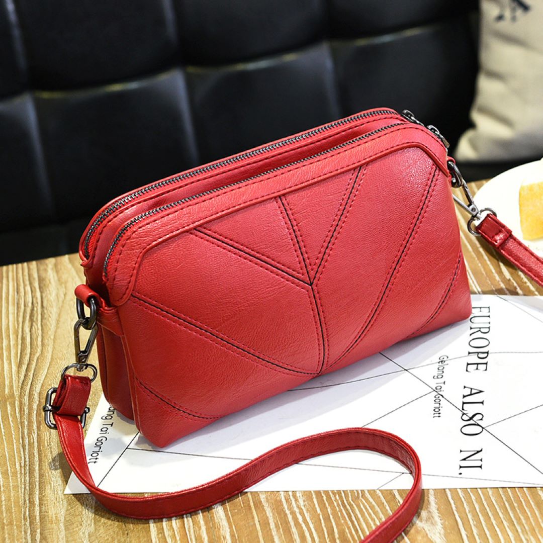 Red Chic Eco Aura Vegan Leather Shoulder Bag positioned on a table