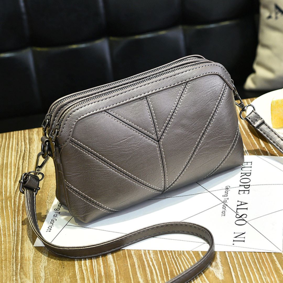 Chic EcoAura Vegan Leather Shoulder Bag in smallbronze grey variant on wooden background