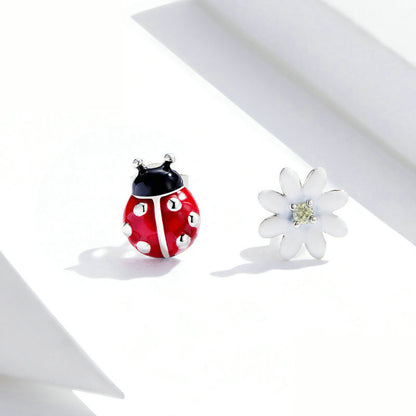 An elegant pair of ladybug theme earrings on a white bckground