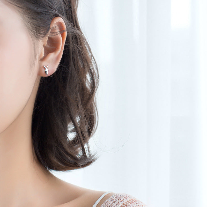 Close view of a woman's ear wearing a silver rabbit theme earring