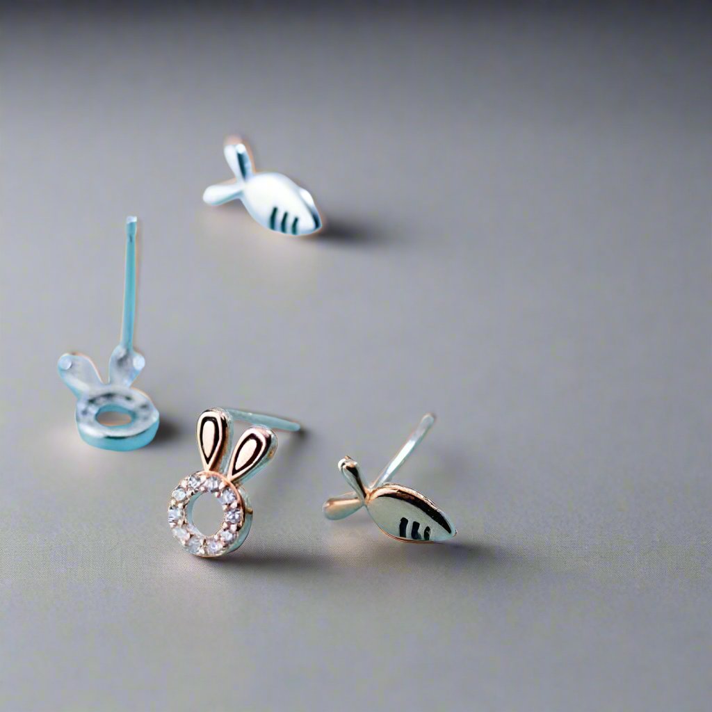 2 pairs of silver rabbit theme earrings on a blue background