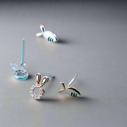 2 pairs of silver rabbit theme earrings on a blue background