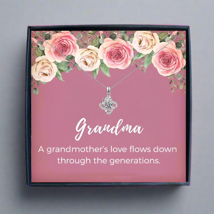 someone holding a pink card box with a silver heart necklace for grandma