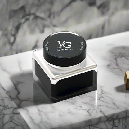 A Night cream for men in a black container with logo over a marble  countertop