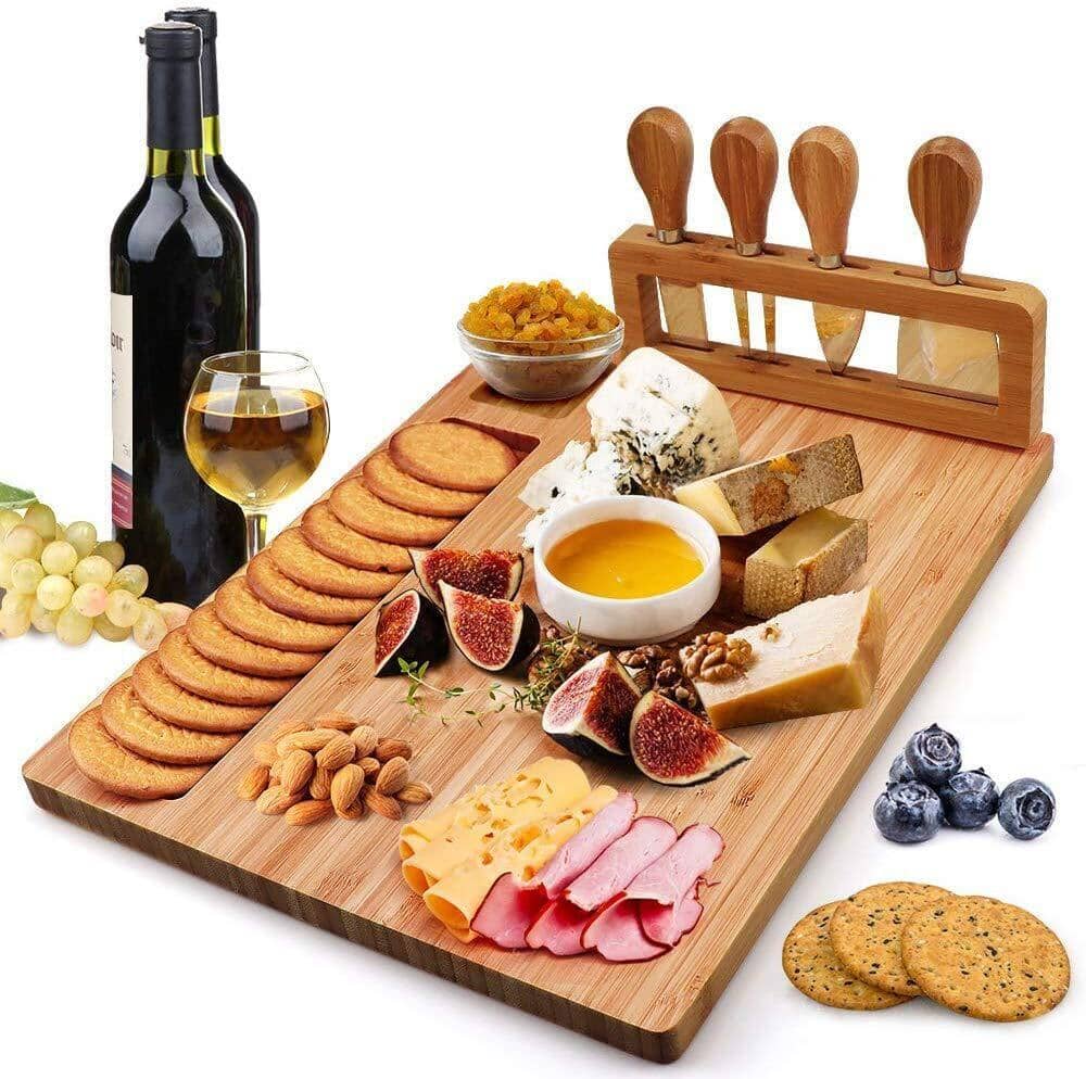 Bamboo cheese board arranged with a selection of cheeses, crackers, and a glass of wine