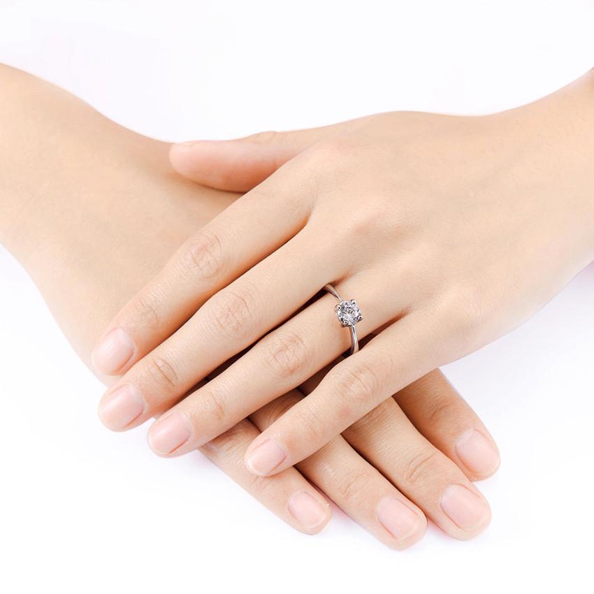 The hands  of a woman wearing a zircon wedding ring