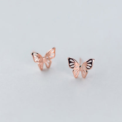 Elegant pair of butterflies gold rose earrings on a clear grey canvas