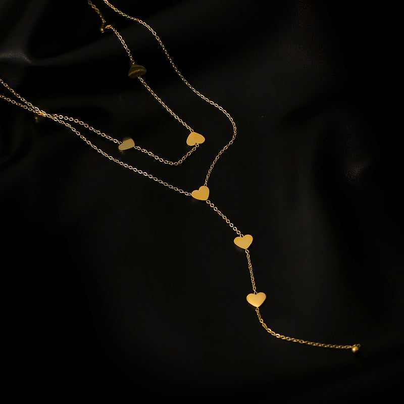 golden hearts long necklace on a black canvas