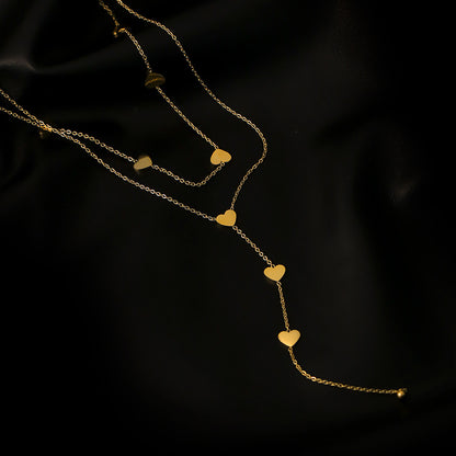 golden hearts long necklace on a black canvas