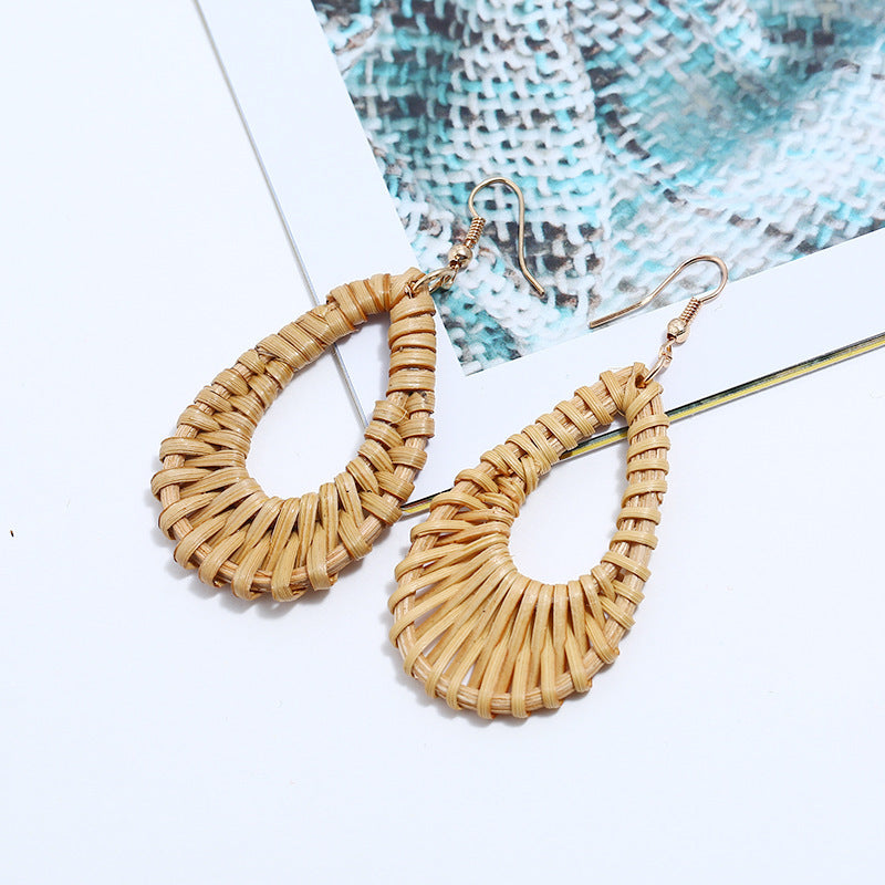 a pair of rattan drop earrings over a white table