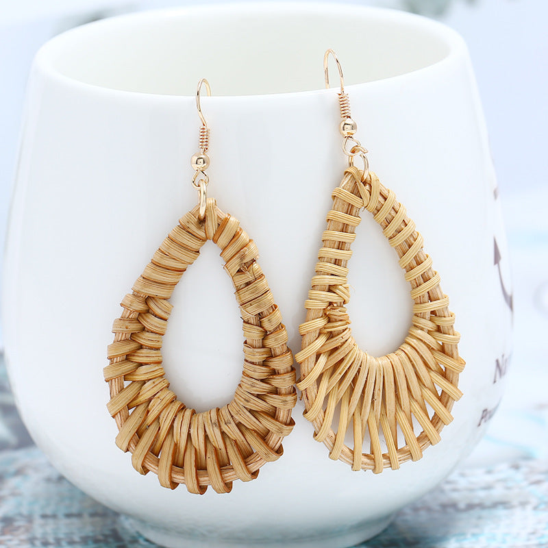 rattan drop earrings hanging on a white vase