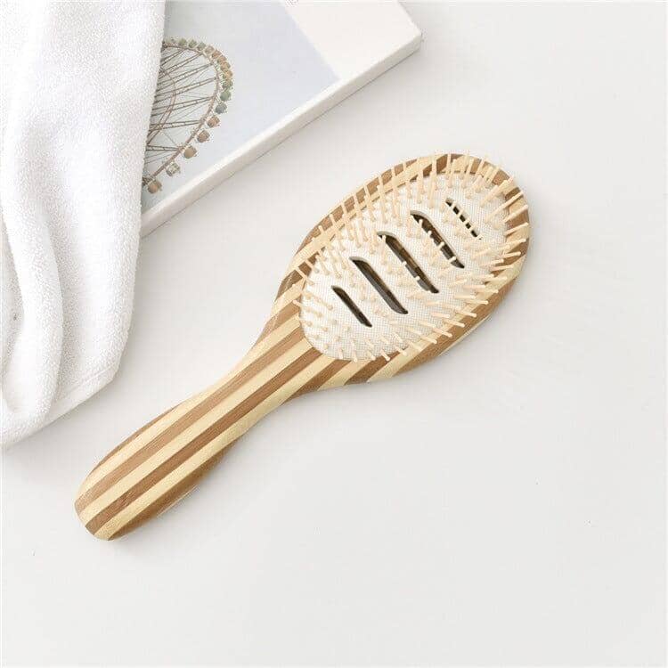 Bamboo scalp massage comb on a fluffy towel