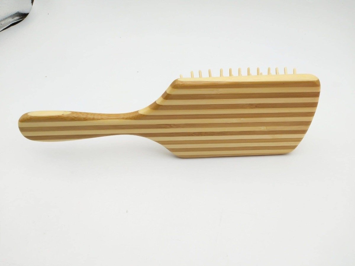 Bamboo hair comb with a convenient handle on a pristine white background
