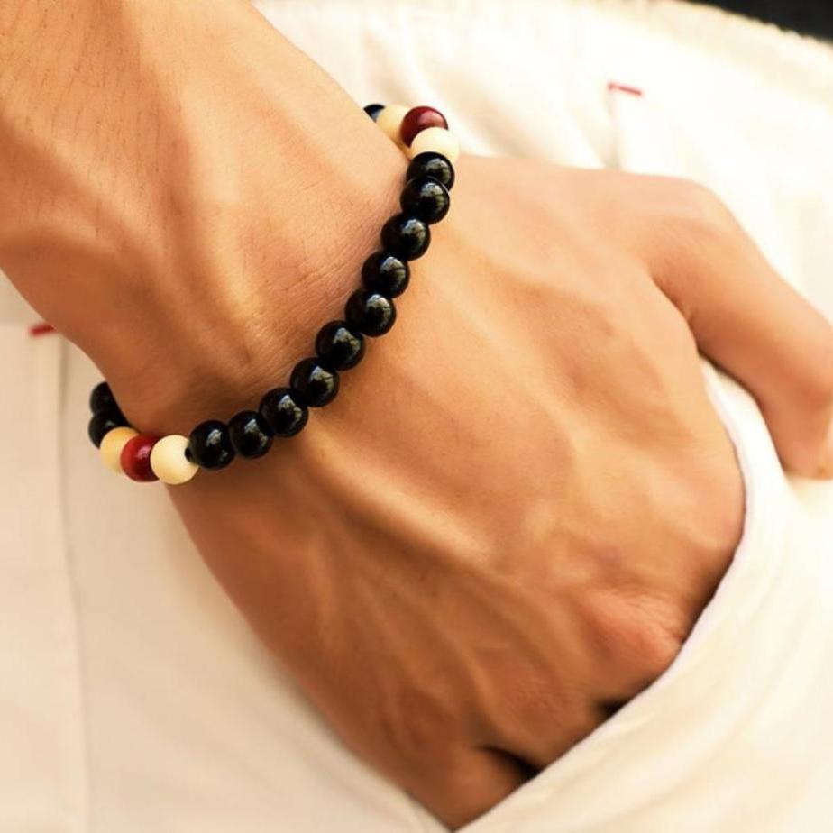 The hand of a person wearing a colored beaded bracelet