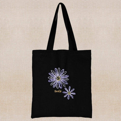 An eco-friendly and sustainable black tote bag with hand painted minimalist flowers