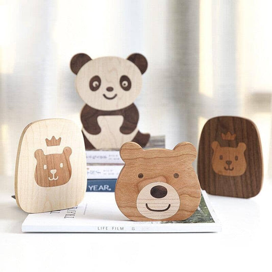 Wooden book stand with bear motif holding a book in place