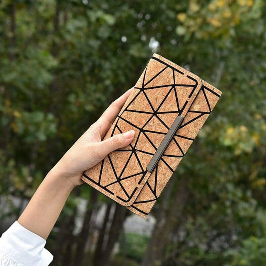 A woman's hand presenting the environmentally friendly cork wallet with intricate geometric patterns