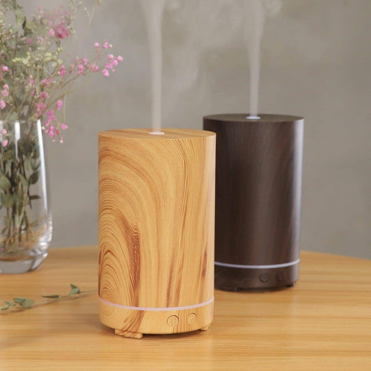 two eco-friendly-wood humidifiers on a wooden surface