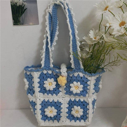 a knitted shoulder bag crochet with a white floral pattern