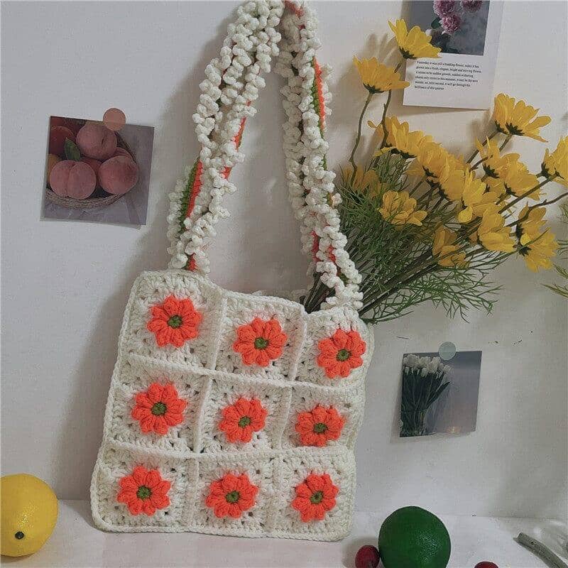 a knitted shoulder bag crochet with a white floral pattern on a photography studio set up