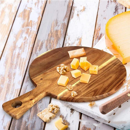 a round wood pizza board with cheese over a wooden countertop 