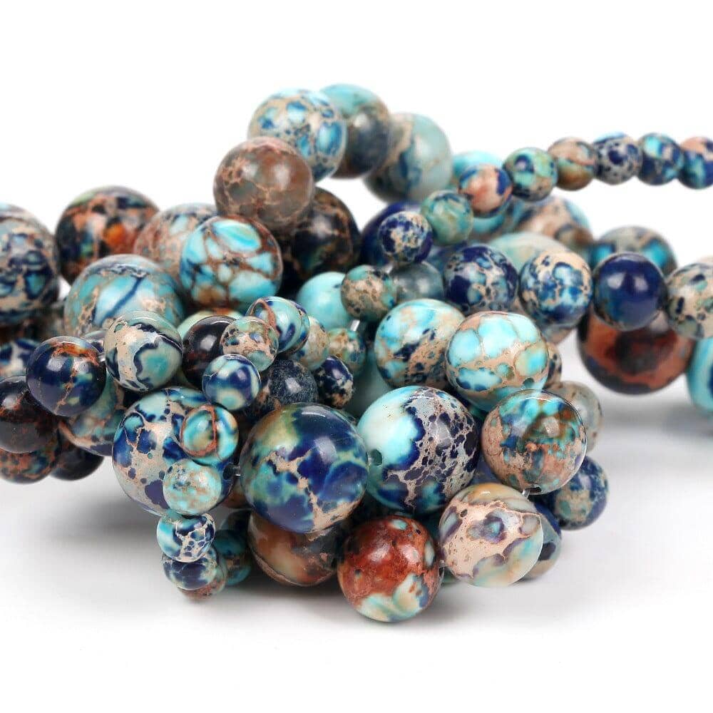 Multiple emperor turquoise beads on a white canvas