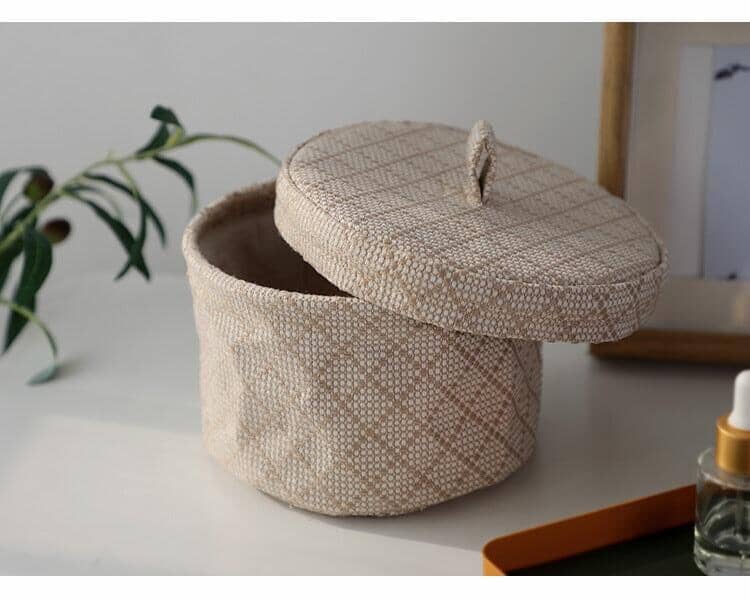beige storage basket in linen and jute with an opened lid