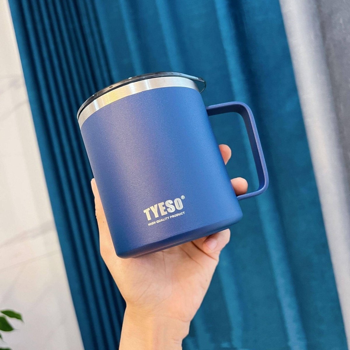 Someone holding an eco-friendly blue stainless steel mug