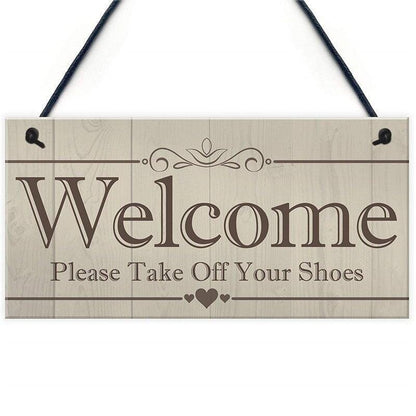 A wooden pendant plaque for home entrance decoration with message to welcome visitors