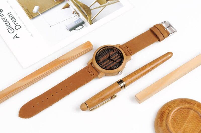 A bamboo wooden men watch besides a wood pen