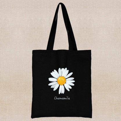 An eco-friendly and sustainable black tote bag with a chamomile flower