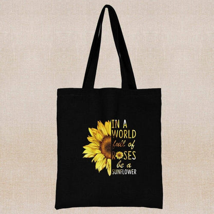 An eco-friendly  black tote bag with a written positive message and a sunflower