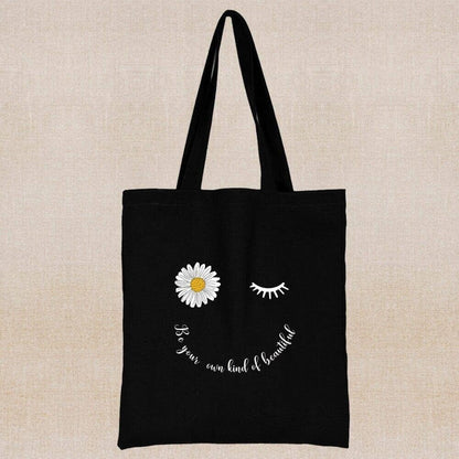 An eco-friendly and sustainable black tote bag with a flower smiling face 